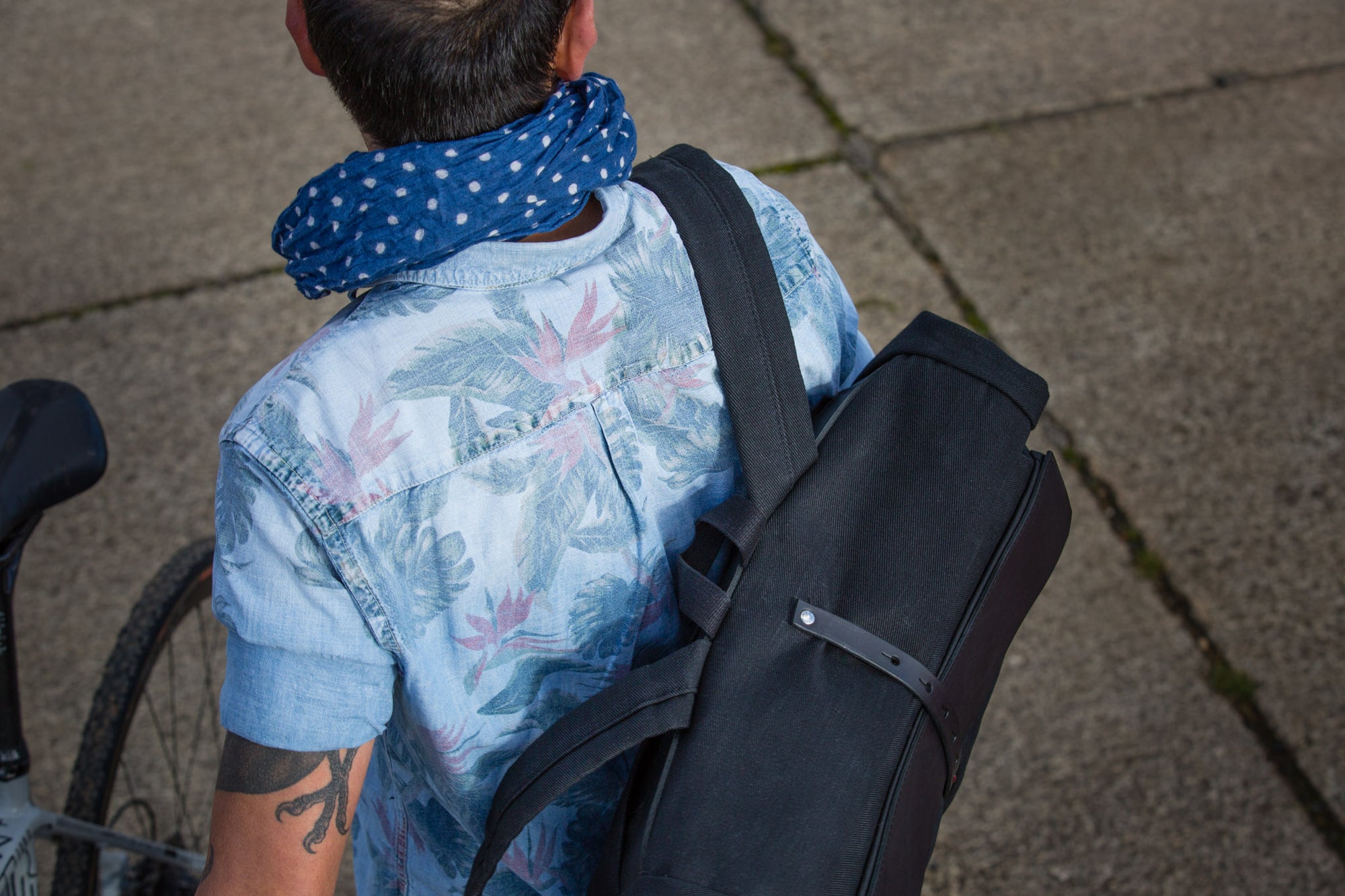 Cyclist carrying a handmade Vel-oh Howl commuter bag